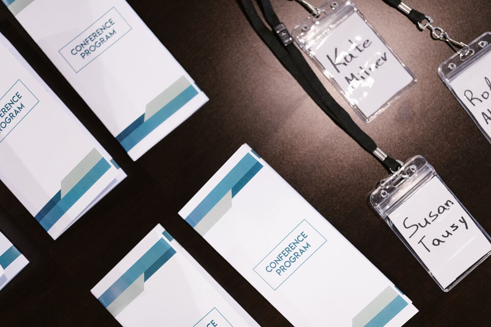 Conference program fliers with name tags on table